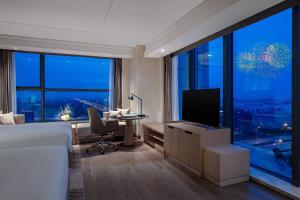 上海上海康桥万豪酒店的一间卧室配有一张床和一张书桌及电视