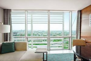 郑州郑州绿地JW万豪酒店的客房设有带沙发和书桌的大窗户。