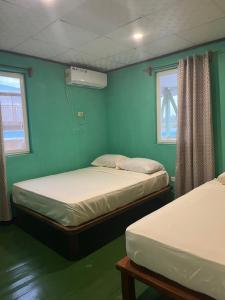 巴斯蒂门多斯Hostal Cay的配有两张床铺的蓝色墙壁和窗户