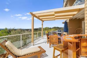 莱伊Ourania Luxury Villa with unforgettable sea views的阳台的天井配有桌椅