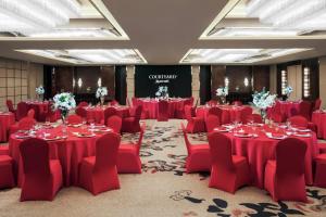 上海上海苏宁环球万怡酒店的一间会议室,配有红色的桌椅和舞台