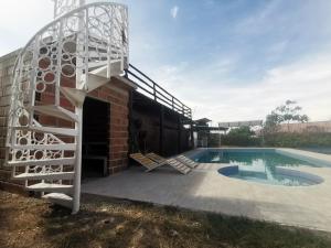 YaguaráQUINTA RANCHO SANTIAGO CAMPESTRE capacidad 50 huéspedes的一座带游泳池和螺旋楼梯的房屋