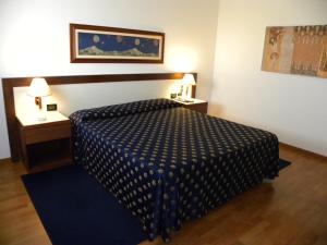 Villanova Monferrato阿尔括特尔酒店的一间卧室配有一张带蓝色和白色棉被的床