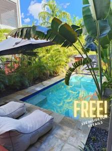 Stuart ParkLush Tropical Paradise Home - Darwin City的一个带枕头和遮阳伞的小型游泳池