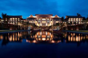 三亚三亚海棠湾万丽度假酒店的一座大型建筑,前面有湖泊