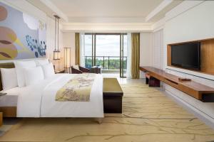 三亚三亚海棠湾万丽度假酒店的配有一张床和一台平面电视的酒店客房