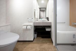 大阪Shizutetsu Hotel Prezio Osaka Shinsaibashi的浴室配有盥洗盆、卫生间和浴缸。