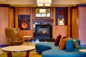 墨尔本Fairfield by Marriott Inn & Suites Melbourne West/Palm Bay的客厅设有蓝色的沙发和壁炉