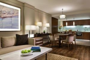 滨海新区天津泰达万豪行政公寓的客厅以及带沙发和桌子的厨房。