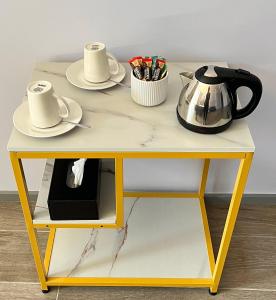 悉尼Sydney RiseOn Hotel的黄色桌子,茶壶和盘子