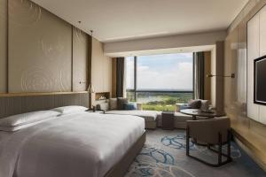 苏州苏州太湖万豪酒店的酒店客房设有一张床和一个大窗户
