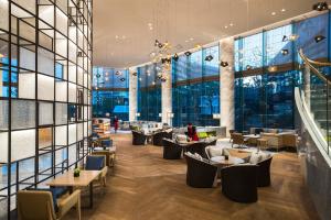 苏州苏州太湖万豪酒店的餐厅设有桌椅和大窗户。