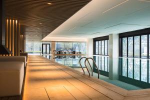 苏州苏州太湖万豪酒店的客房设有带椅子和窗户的游泳池。