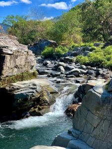 BanguedLayugan garden resort bucay abra的一条有岩石的河流和山底