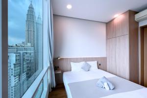 吉隆坡吉隆坡会展中心勒雅拉套房公寓的卧室设有白色的床和大窗户