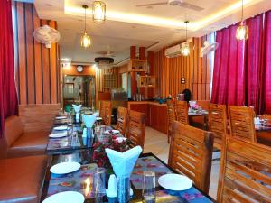 PūrniaHotel sunshine & restaurant的一间带长桌和椅子的用餐室