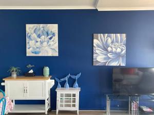LarrakeyahMarina Views Apartment Cullen Bay的一间蓝色墙上有两幅画的房间