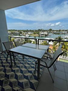 LarrakeyahMarina Views Apartment Cullen Bay的阳台配有桌椅,享有水景