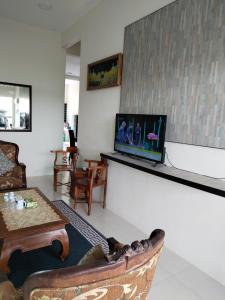 实兆远Lekir baiduri homestay的客厅配有沙发和墙上的电视
