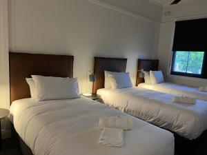 沃加沃加Sportsmens Club Hotel的酒店客房,配有两张带毛巾的床