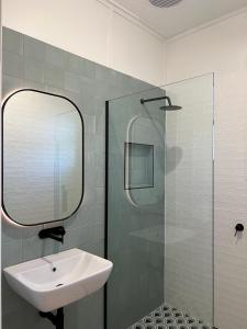 沃加沃加Sportsmens Club Hotel的一间带水槽和玻璃淋浴的浴室