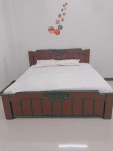 乌贾因Narayan nivas homestay的一张带木制床头板的床和墙上的一些按钮