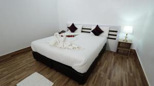 沙湾拿吉Bouasavan Hotel and Garden的卧室配有一张白色大床,上面有天鹅