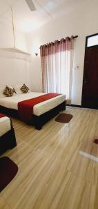 锡吉里亚SMW Lodge Sigiriya的一间卧室配有一张床,铺有木地板