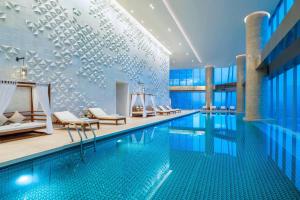长沙长沙梅溪湖金茂豪华精选酒店的游泳池,酒店内设有椅子和游泳池