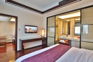 上海上海柏阳君亭酒店的一间卧室配有一张床、一个水槽和一台电视