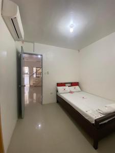 MaribagoWJV INN MARIBAG0的一间卧室设有一张床,门通往走廊