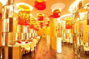 郑州郑州上街雅乐轩酒店 的一间设有白色桌子和红色吊灯的用餐室