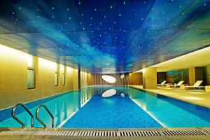 郑州郑州上街雅乐轩酒店 的一座大型游泳池,拥有星空天花板