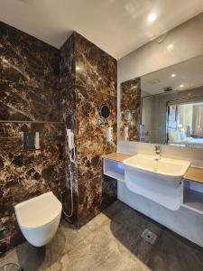 达兰萨拉Portola Hotel By Parkside的一间带水槽、卫生间和镜子的浴室