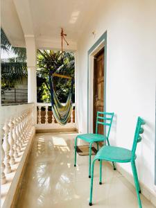 阿姆波尔Tranquilo Arambol的门廊配有2把椅子和吊床