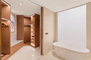 阿吉曼Ajman Hotel by Blazon Hotels的一间带大浴缸和步入式衣柜的浴室