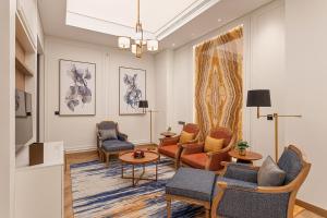 阿吉曼Ajman Hotel by Blazon Hotels的客厅配有椅子、沙发和桌子