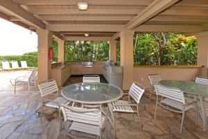卡哈纳Paki Maui 424的一个带两张桌子和椅子的庭院和一间厨房