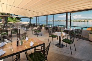 佩特坎内泊尼欧酒店的一间带桌椅并享有水景的餐厅