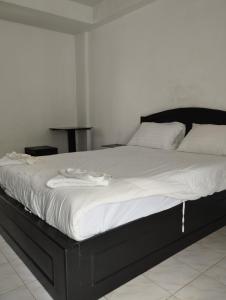 象岛SP.Place Hotel Koh Chang的一张配有黑色框架和白色床单的大床
