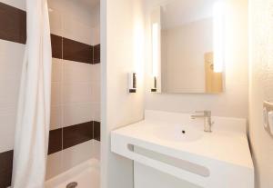 波城B&B HOTEL Pau Zénith的白色的浴室设有水槽和淋浴。