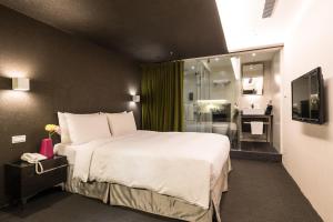台北凡登台北商務旅店的一间带大床的卧室和一间浴室