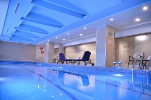 伊斯兰堡伊斯兰堡万豪酒店 的一个带椅子和桌子的大型游泳池