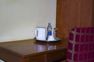 利隆圭Demera Motel的一张桌子、一个咖啡壶和一瓶水
