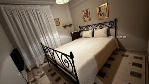 阿拉霍瓦Tripio Lithari - Arachova Vacation Home的一间卧室配有一张黑色床和白色床罩
