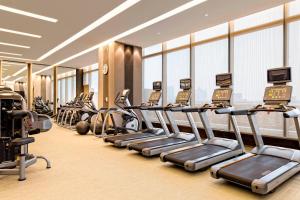 义乌义乌万豪酒店的健身房,配有一排跑步机和机器