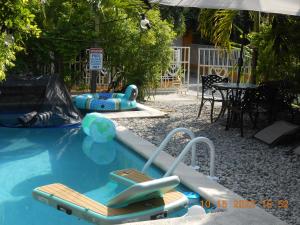太子港Gustave Vacation House的一个带两把椅子和一张桌子的游泳池