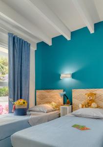 克洛阿尔卡尔诺厄KER-AR-MOR Village Vacances的一间卧室设有两张床和蓝色的墙壁