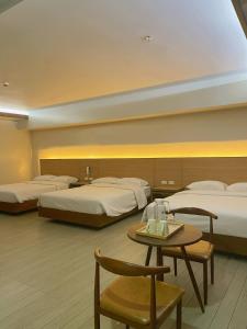 碧瑶Soleo Inn的酒店客房设有两张床和一张桌子。