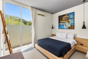 拉扬海滩度Villa Sunpao的一间卧室设有一张床和一个大窗户